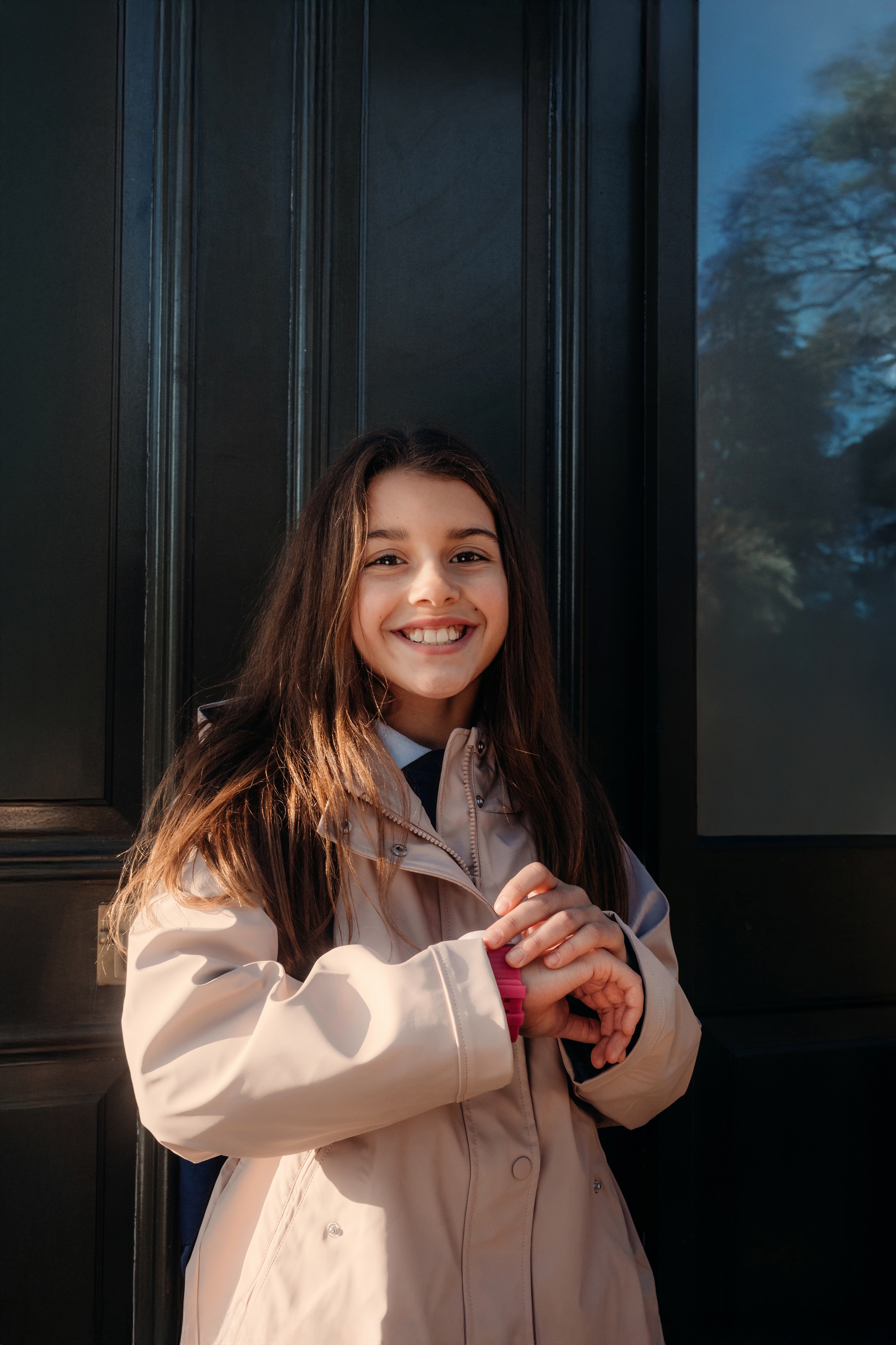 Niña feliz usando su reloj inteligente Xplora con diseño rosa, ideal para niños; combina estilo y seguridad en exteriores.